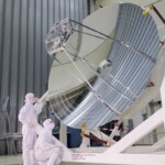 Inspection dans une salle blanche de l’ESTEC du modèle de vol du télescope Herschel avec son miroir primaire de 3,5m de diamètre, le plus grand miroir construit à ce jour pour l’astronomie spatiale.